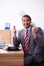 Young male employee inserting flash drive into laptop