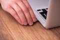 Young male employee inserting flash drive into laptop