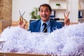 Young male employee and a lot of cut papers in the office Royalty Free Stock Photo