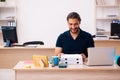 Young male employee ordering pizza at workplace