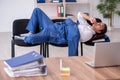 Young male employee sleeping in the office on chairs Royalty Free Stock Photo