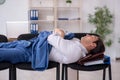 Young male employee sleeping in the office on chairs Royalty Free Stock Photo