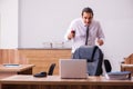 Young male employee stapling paper in the office Royalty Free Stock Photo