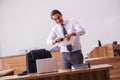 Young male employee stapling paper in the office Royalty Free Stock Photo