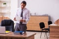 Young male employee stapling paper in the office Royalty Free Stock Photo