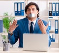 Young male employee with tape on the mouth