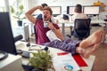 A young male employee is trying to stay awake while working in the office. Employees, job, office Royalty Free Stock Photo