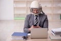 Young male employee wearing spacesuit in the office