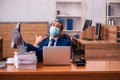 Young male employee working in the office wearing mask Royalty Free Stock Photo
