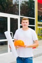 Young Male Engineer Construction worker holding building plan . Construction worker with plan of work on the background of freshly Royalty Free Stock Photo