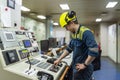 Young marine engineer during his daily routine work in engine room. Seafarers life. Royalty Free Stock Photo