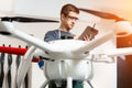 Young Male Engineer or Technician with Holding Tablet in His Hands Programs Drone. Royalty Free Stock Photo