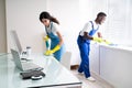 Male And Female Cleaners Cleaning Office