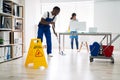 Male And Female Cleaners Cleaning Office Royalty Free Stock Photo