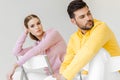 young male and female models in pink and yellow hoodies sitting on chairs Royalty Free Stock Photo