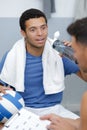 Young male footballer with coach drinking water Royalty Free Stock Photo