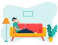 A young male freelancer with dark hair is lying on the sofa holding a laptop. The concept of remote work, study from home. Home Royalty Free Stock Photo