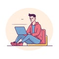 Young male freelancer working remotely using laptop. Man seated floor leaning against cushion