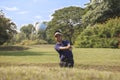 Young male golf player grey pants chipping golf ball out of a sa Royalty Free Stock Photo