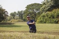 Young male golf player grey pants chipping golf ball out of a sa Royalty Free Stock Photo