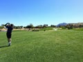 A young male golfer hitting his approach shot from the middle of the fairway on a par 4 on a golf course in Palm Springs Royalty Free Stock Photo