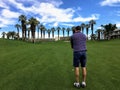 A young male golfer lining up his approach shot from the middle of the fairway on a par 4 on a golf course in Palm Springs Royalty Free Stock Photo