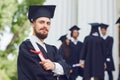 A young male graduate against the background of university graduates. Royalty Free Stock Photo