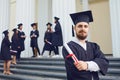 A young male graduate against the background of university graduates. Royalty Free Stock Photo