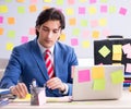 Young male handsome employee in conflicting priorities concept Royalty Free Stock Photo