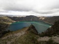 Young male hiker in blue jacket at andean volcano caldera crater lake Quilotoa rim ridge loop Cotopaxi Ecuador andes Royalty Free Stock Photo