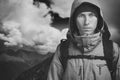 Young male hiker on cloudy landscape background looking at camera. Front view. Active lifestyle and tourism black and