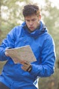 Young male hiker reading map in forest Royalty Free Stock Photo