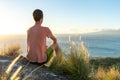 Young male hiker sitting on the summit of Diamond Head Crater in Honolulu, Oahu, Hawaii, looking down to Waikiki Beach and the cit Royalty Free Stock Photo