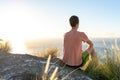 Young male hiker sitting on the summit of Diamond Head Crater in Honolulu, Oahu, Hawaii, looking down to Waikiki Beach and the cit Royalty Free Stock Photo