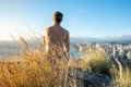 Young male hiker sitting on the summit of Diamond Head Crater in Honolulu, Oahu, Hawaii, looking down to Waikiki Beach Royalty Free Stock Photo