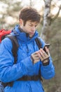 Young male hiker using smart phone in forest Royalty Free Stock Photo