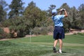 Young male hitting golf ball