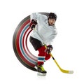 Young male hockey player with the stick on ice court and white background Royalty Free Stock Photo