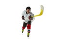 Young male hockey player with the stick on ice court and white background Royalty Free Stock Photo