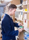 Young male joiner searching for items at workplace