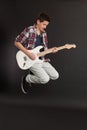 Young male jumping with guitar