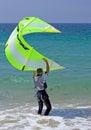 Young male kitesurfer holding kite steady