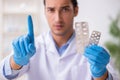 Young male lab assistant in drug synthesis concept