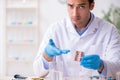 Young male lab assistant in drug synthesis concept