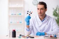 Young male lab assistant in drug synthesis concept