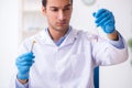 Young male lab assistant in drug synthesis concept