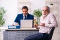 Young male lawyer and old man in testament and time management c Royalty Free Stock Photo