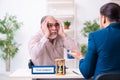 Young male lawyer and old man in testament and time management c Royalty Free Stock Photo