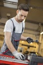 Young male maintenance engineer arranging tools in drawer at car workshop Royalty Free Stock Photo