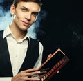 Young male make up artist holding shadow palette and brush. Royalty Free Stock Photo